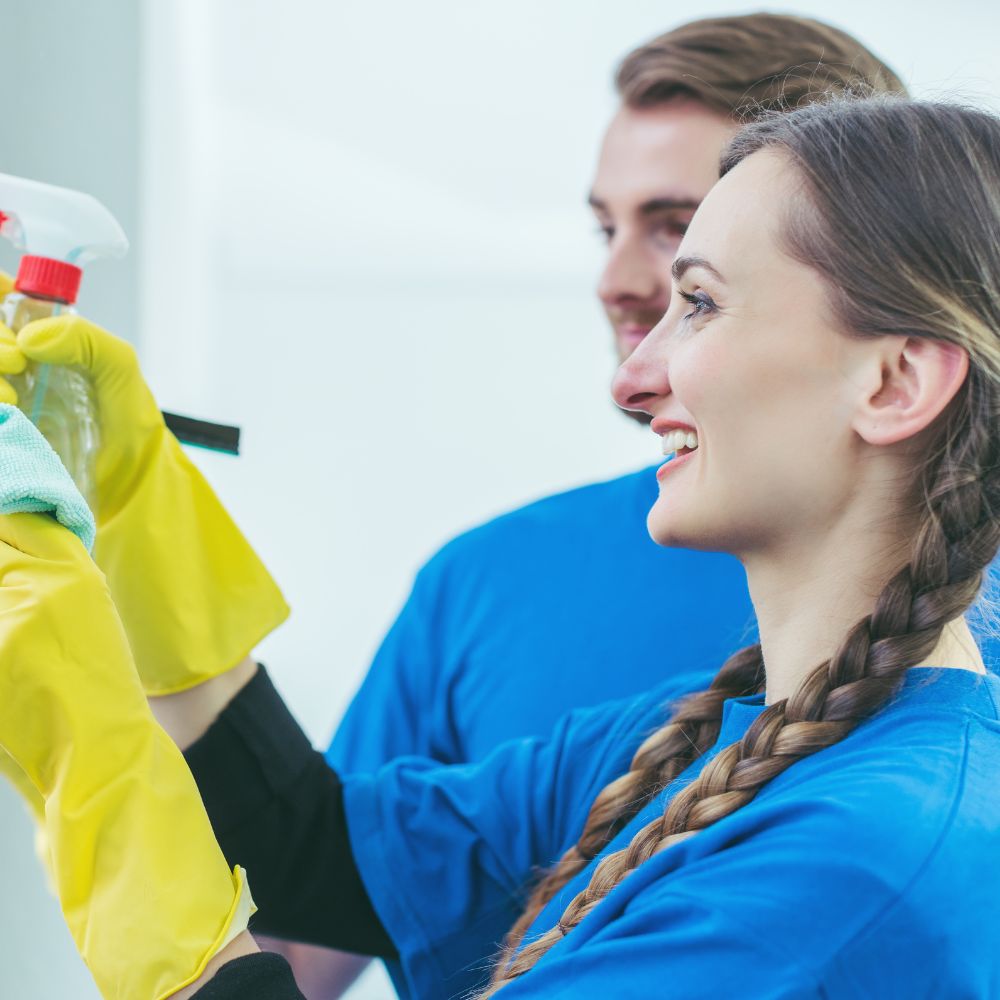 Professional cleaning team members working together with cleaning supplies and equipment